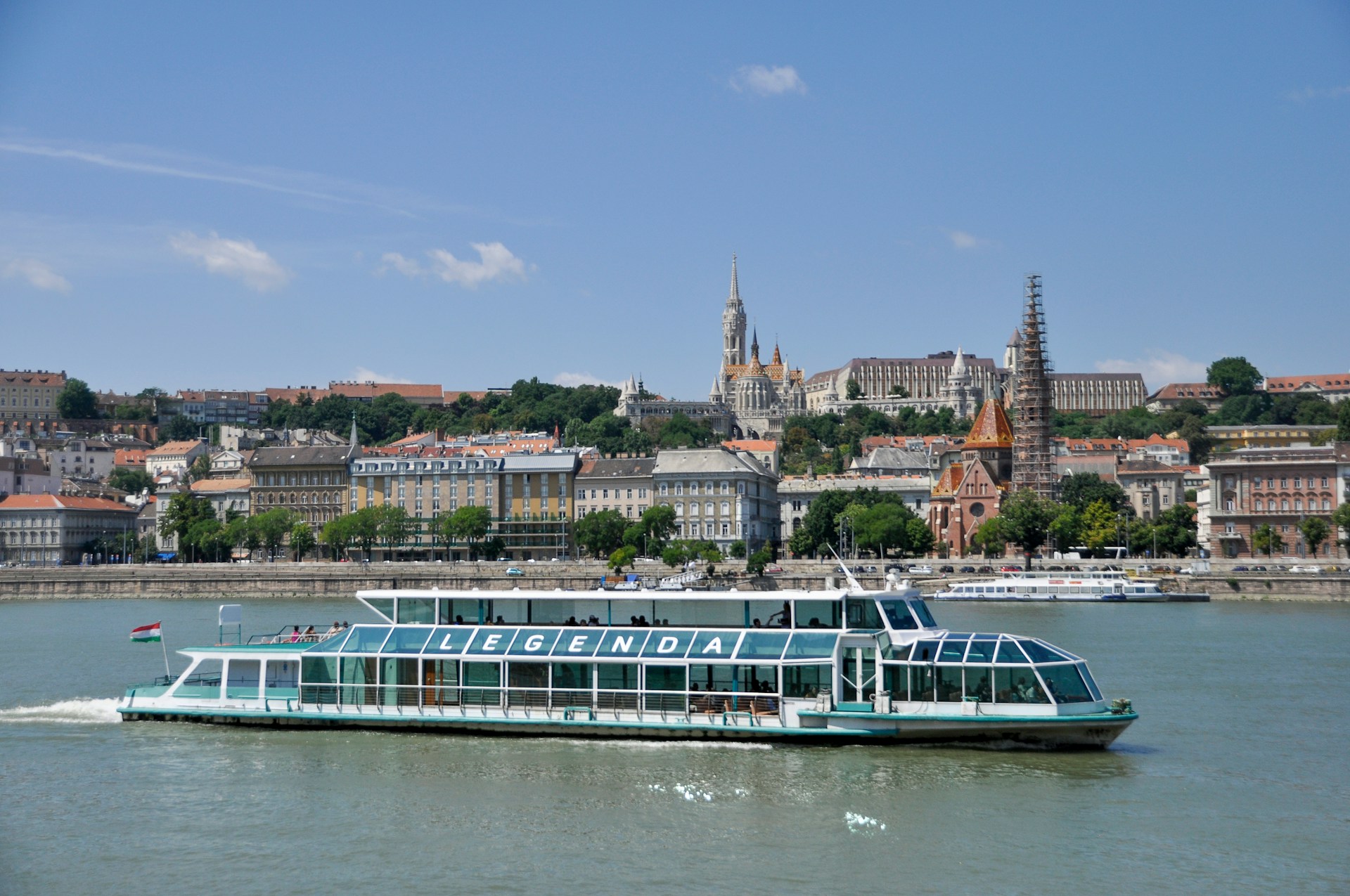 A luxury river cruise ship gliding down the Danube past the illuminated Parliament of Budapest