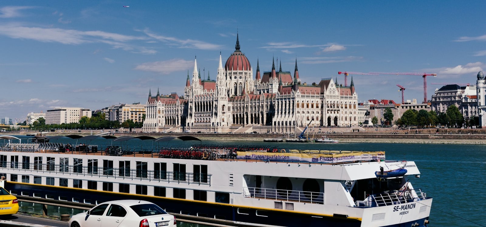A river cruise ship sailing the Danube past the Hungarian Parliament, Budapest
