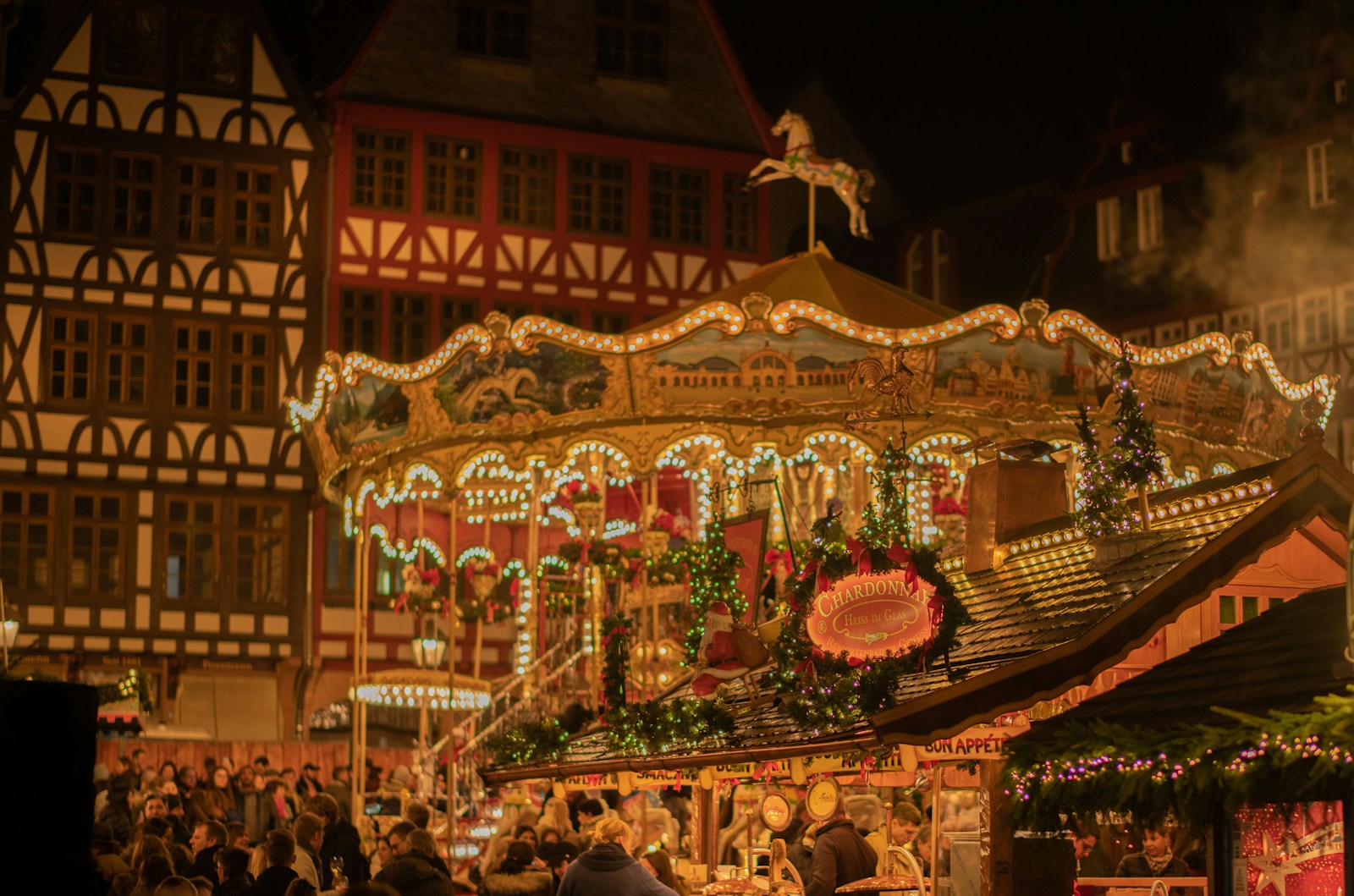The carousel and stalls of the Frankfurt Christmas market glowing at dusk
