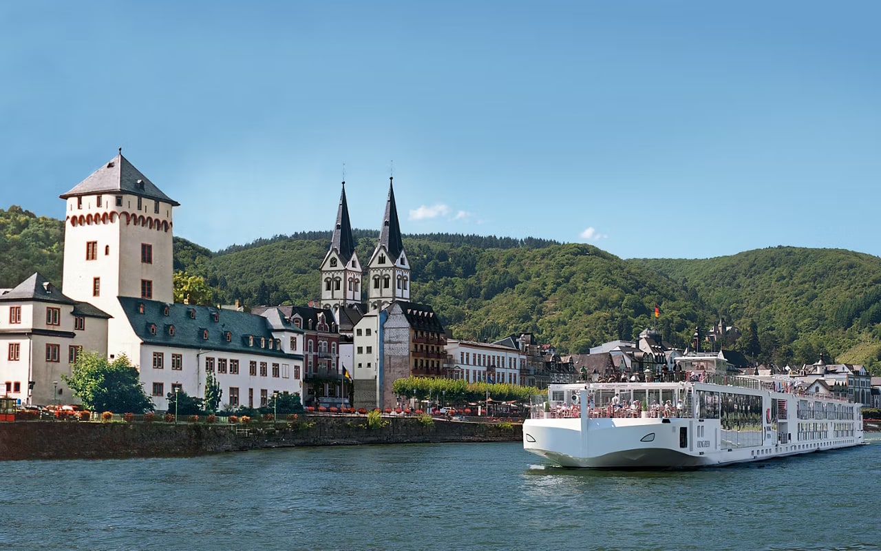 A Viking longship sailing the Rhine past the waterfront and church spires of Boppard, Germany